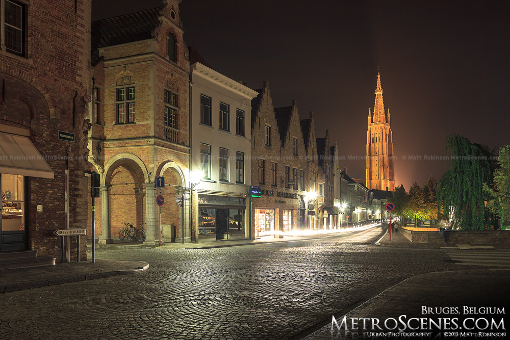 Illuminated spire of Church of Our Lady at night in Bruges