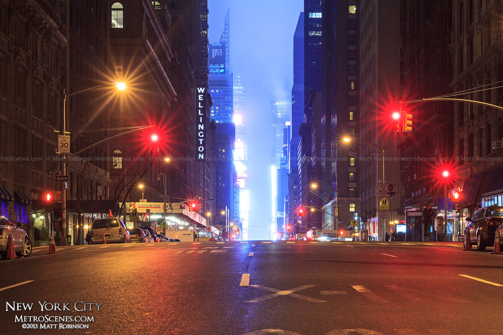 The glow of Times Square at night as seen from 7th Avenue near Central Park